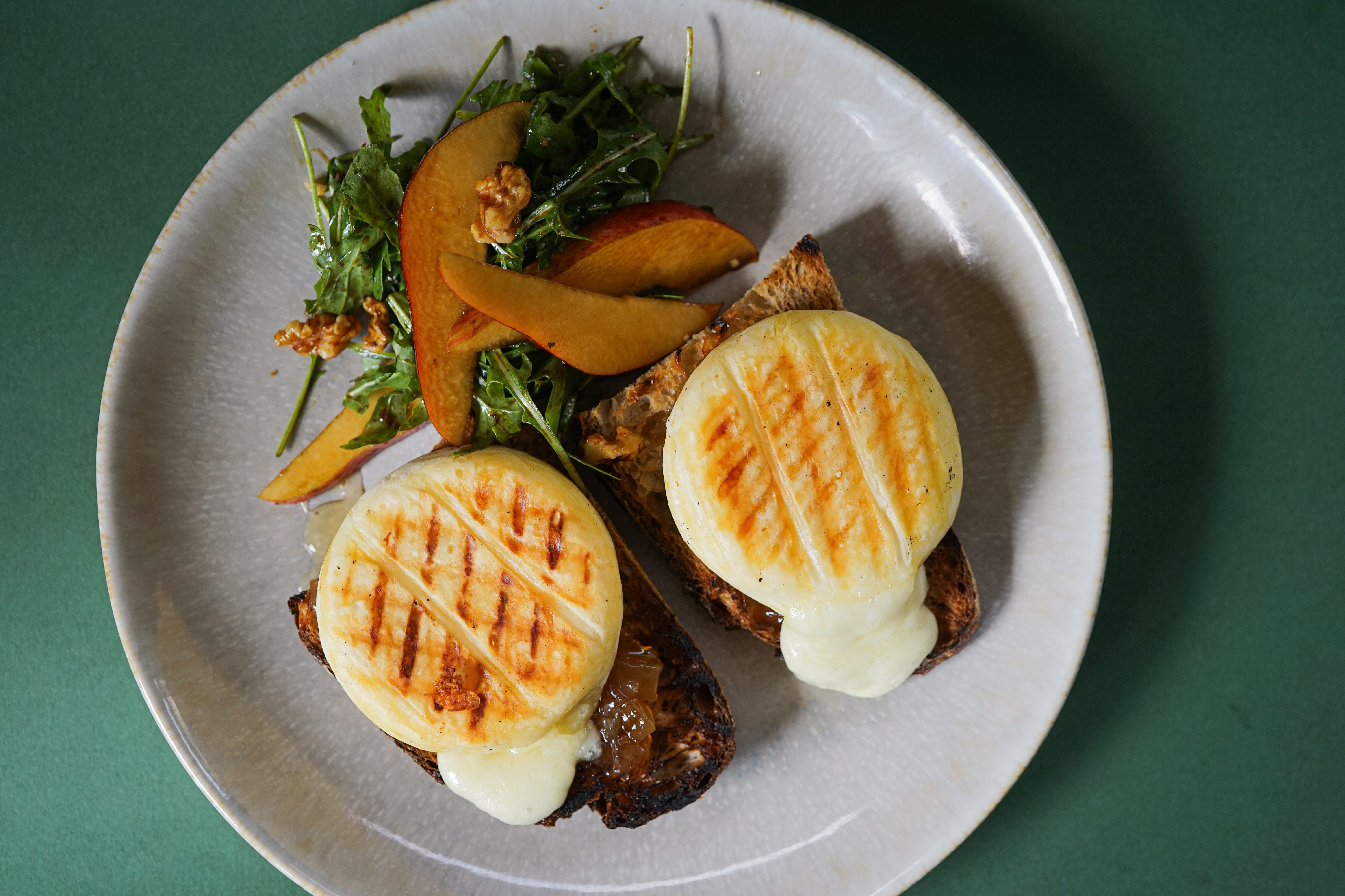 Bruschetta topped with molten grilled Tomino cheese and onion jam, served with pear-arugula salad and drizzled with balsamic vinegar