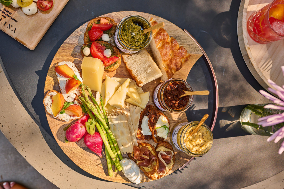 Antipasti board with cured meats, cheeses, olives, and crostini on a wooden platter