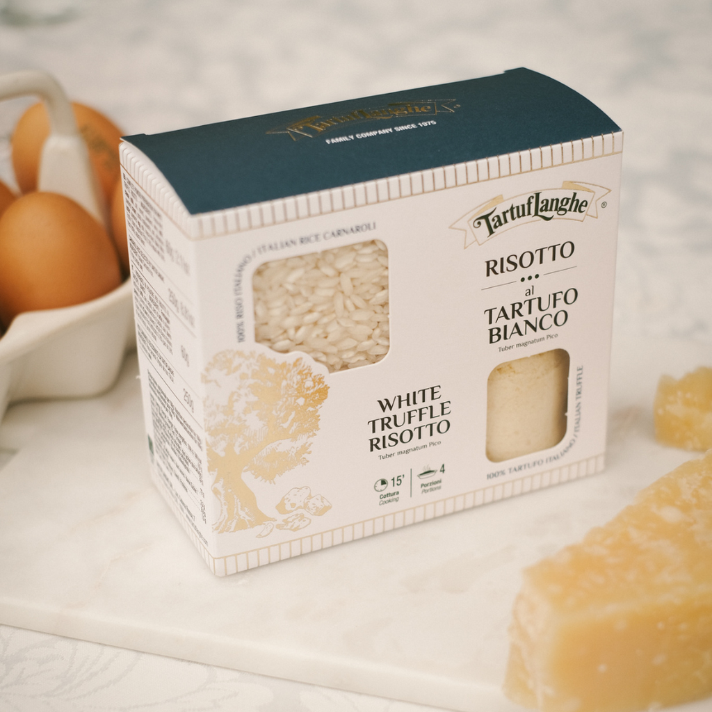 Box of Tartuflanghe White Truffle Risotto on a marble surface with eggs and parmesan cheese.