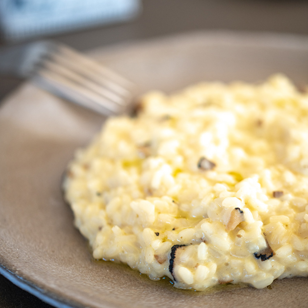 Risotto on a plate with a fork, blurred background