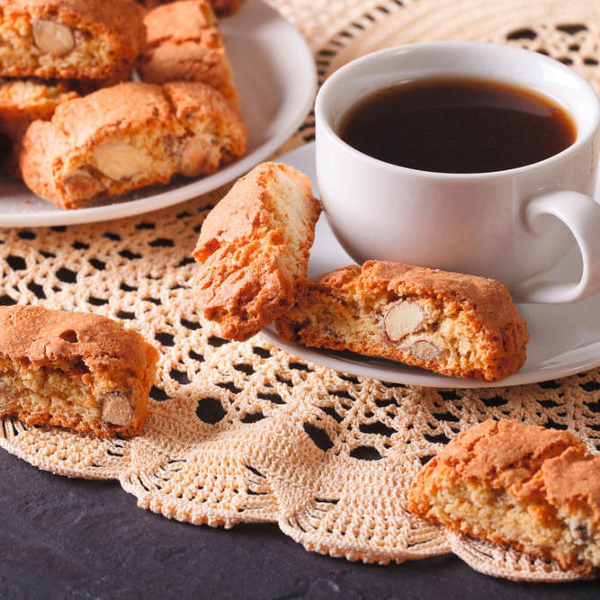 Classic Italian almond cantucci biscotti served with coffee on a lace table setting