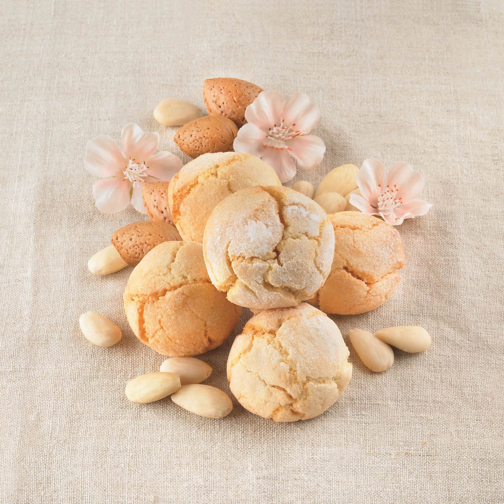 Soft Amaretti Virginia almond cookies with almonds and blossoms on fabric background