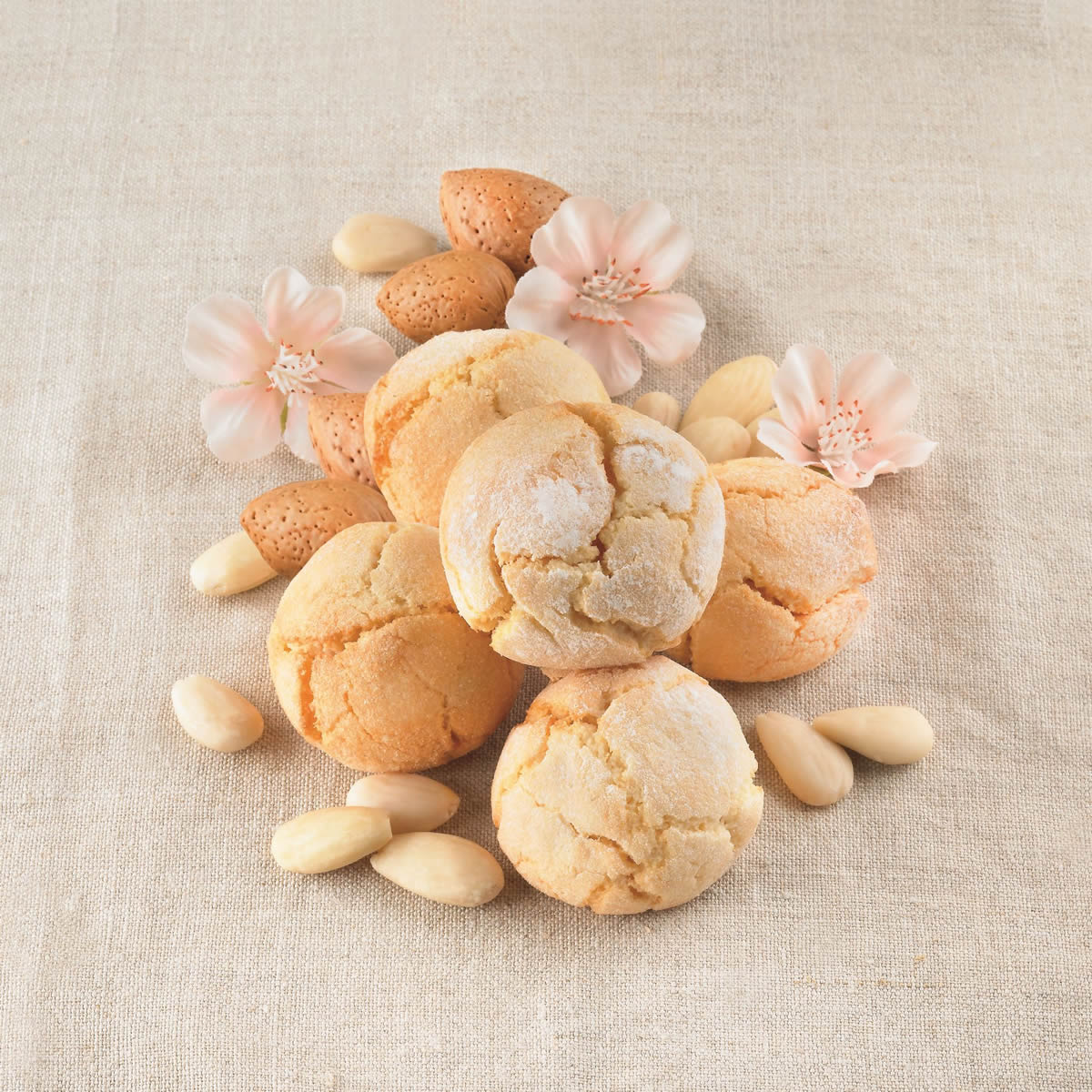 Soft Amaretti Virginia almond cookies with almonds and blossoms on fabric background