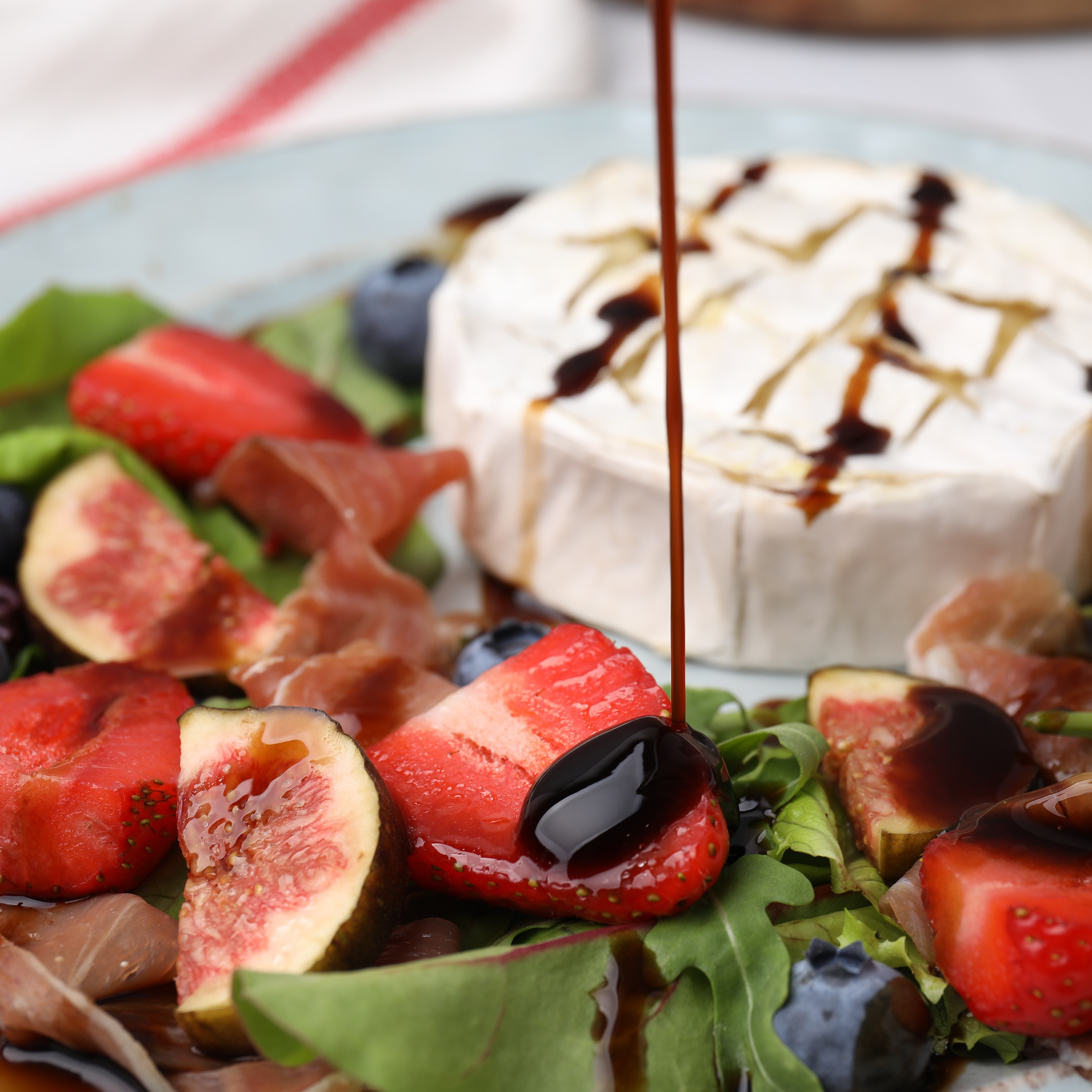 Rich, dark balsamic vinegar of Modena being drizzled over a fresh salad, Masserie di Santeramo