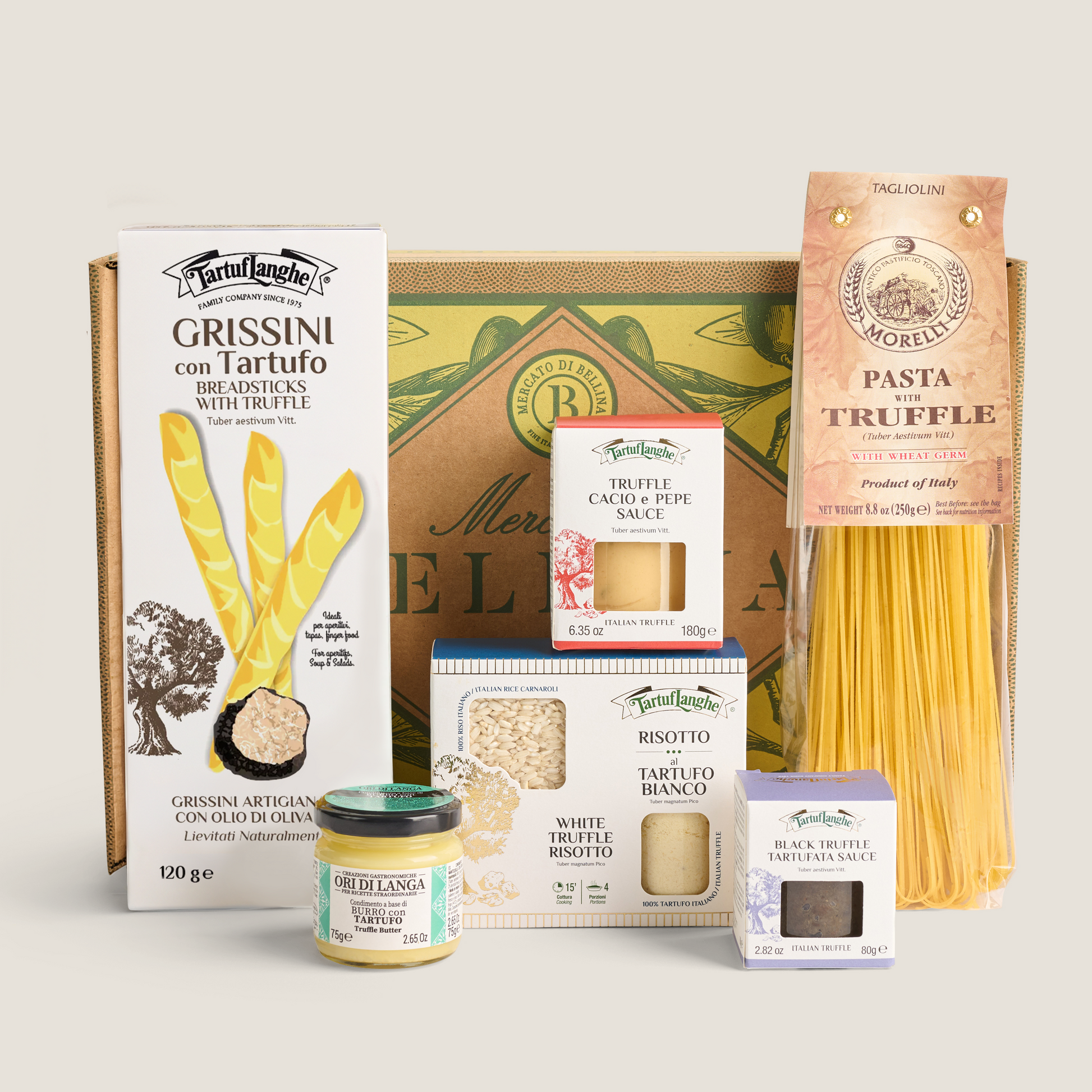 A curated gourmet gift set from Mercato di Bellina featuring truffle products, pasta, and sauces arranged in front of a decorative gift box on a light beige background. The set includes Grissini con Tartufo, Pasta Truffe, Truffe Cacio e Pepe , Risotto, White Truffe Butter, Black Truffe sauce.