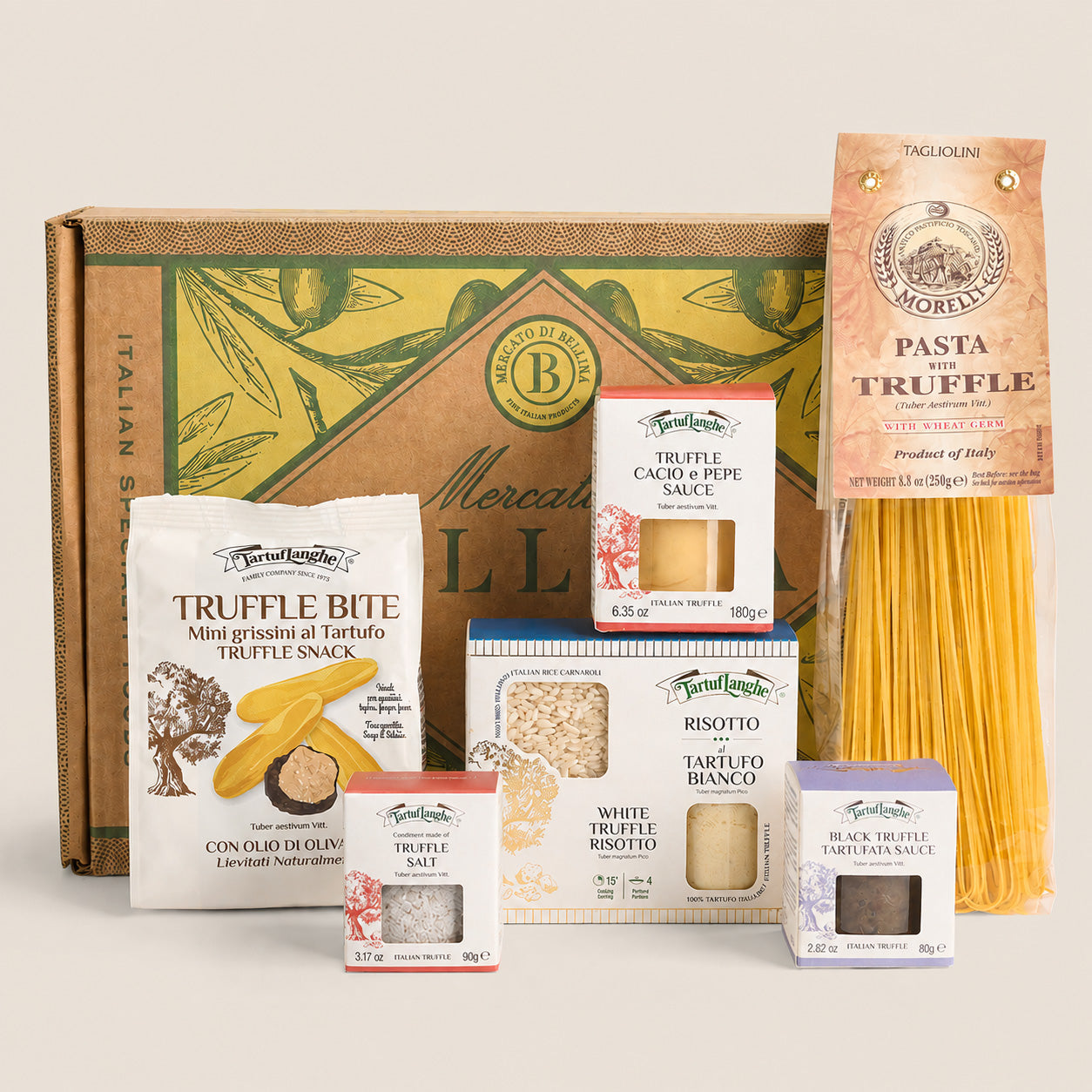 A curated gourmet gift set from Mercato di Loreto, featuring a large olive-green and brown cardboard trunk box alongside an assortment of packaged food items including Truffle Bite, Pasta Truffe, Risotto, and Truffe Saffi, arranged neatly on a light beige background.