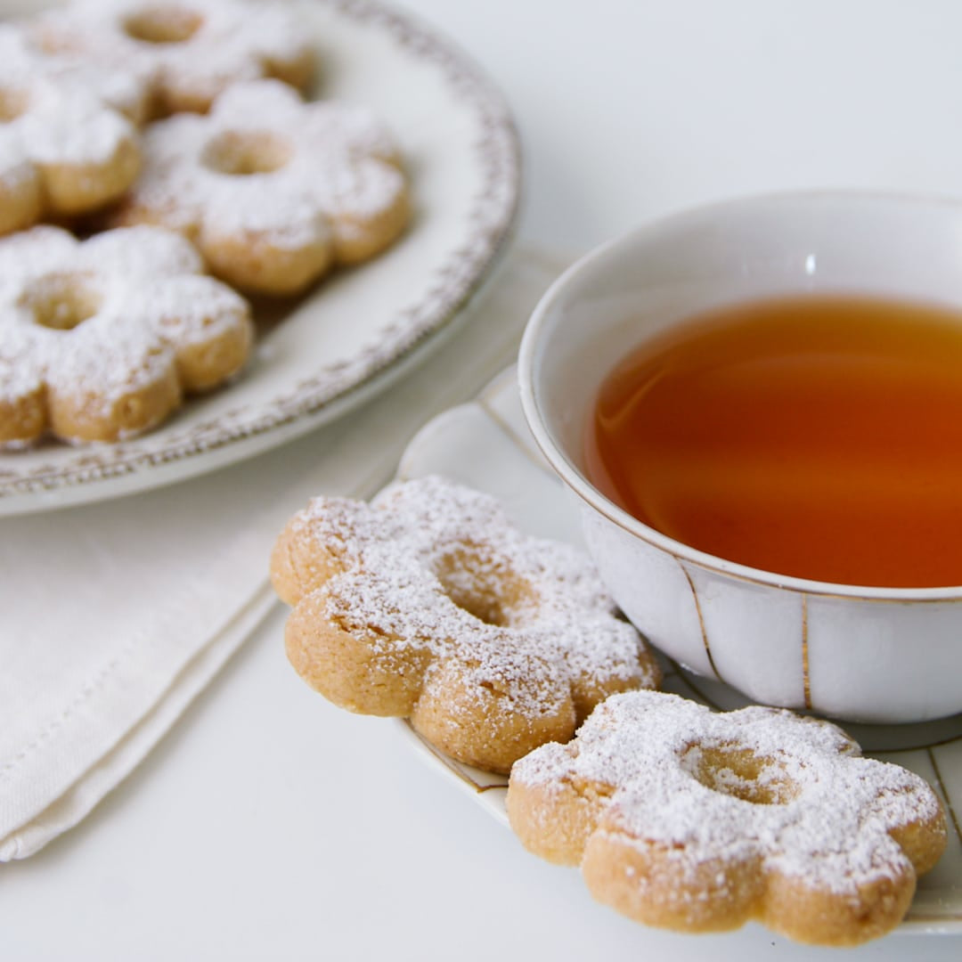 Flower-shaped Canestrelli cookies dusted with sugar served with tea