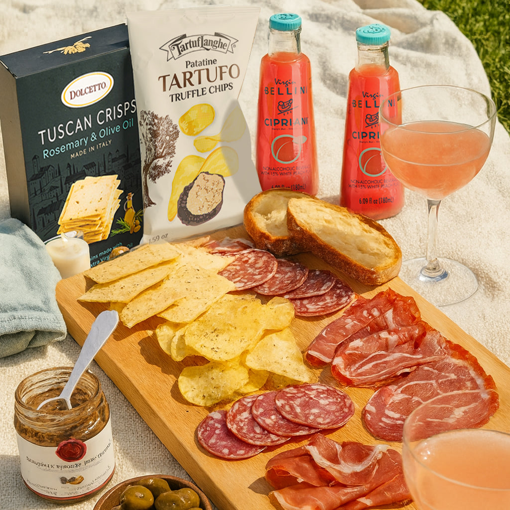 Aperitivo picnic board with Tuscan crisps, truffle chips, cured meats, and Bellini cocktails