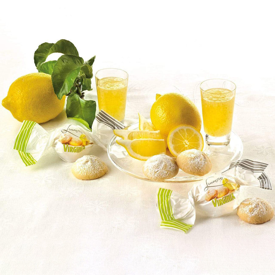Lemon shortbread biscuits with fruit preserve filling displayed with fresh lemons and limoncello