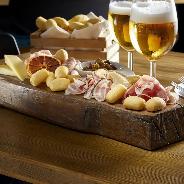 Aperitivo board with cured meats, cheese, olives, beer, and Imacoritti Grissini Bites