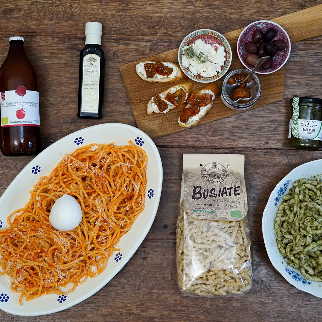 Diverse food items including pasta, olive oil, and bread on a wooden table. video of cooking Italian food ingredients, authentic pasta and condiments. making Italian Sunday dinner